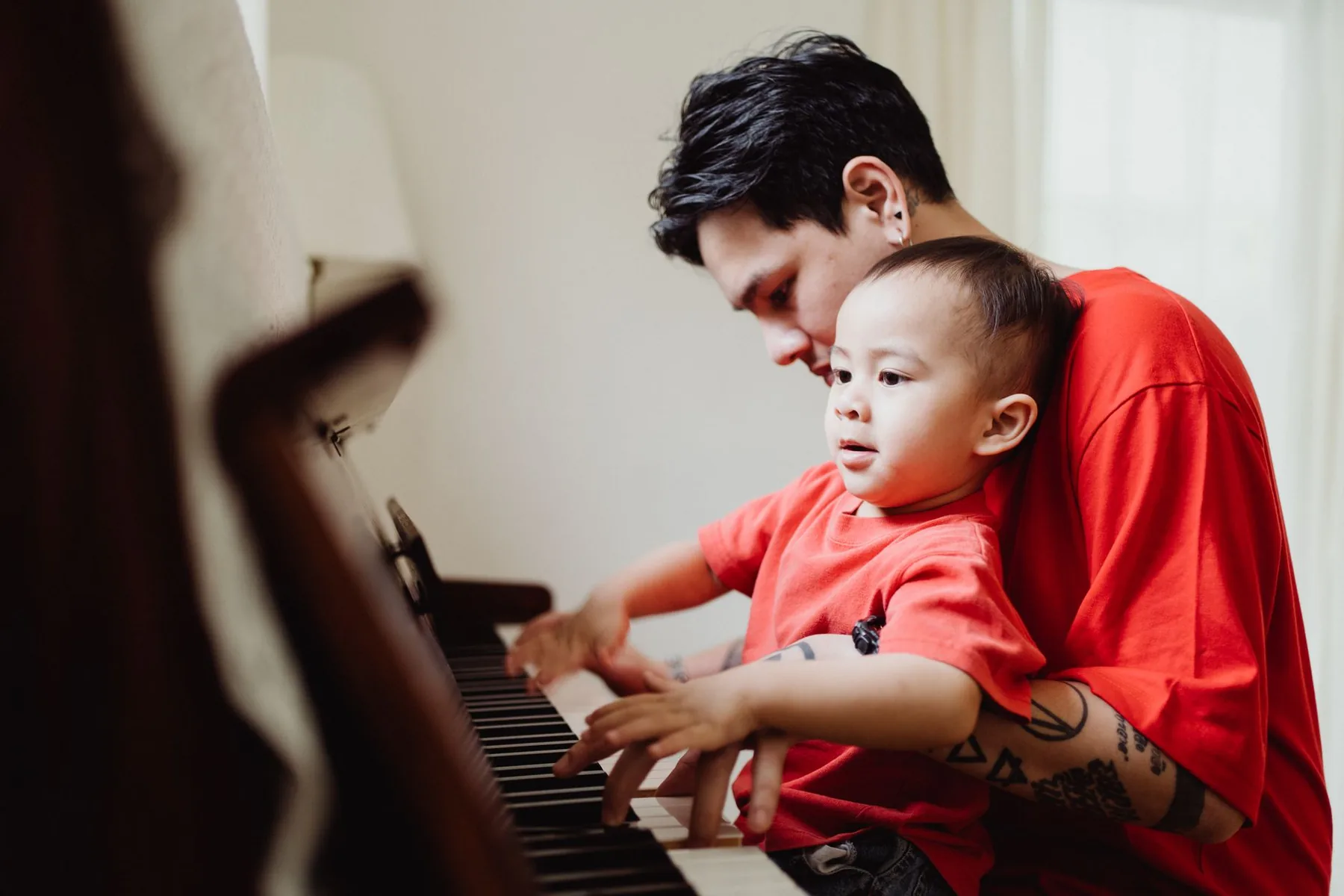 Parent and child playing the piano Parent and child playing the piano