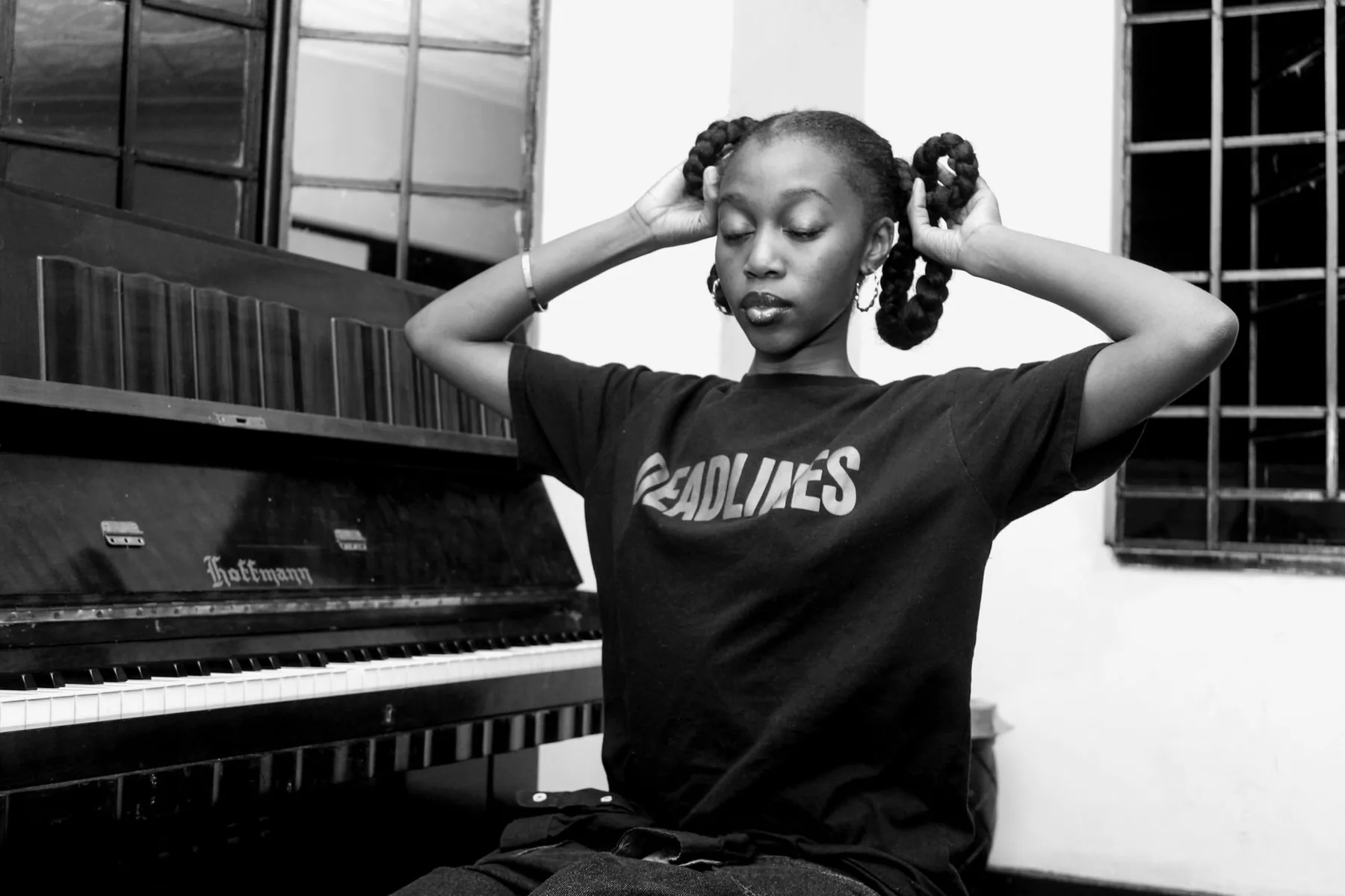 Young female musician near an upright piano Young female musician near an upright piano